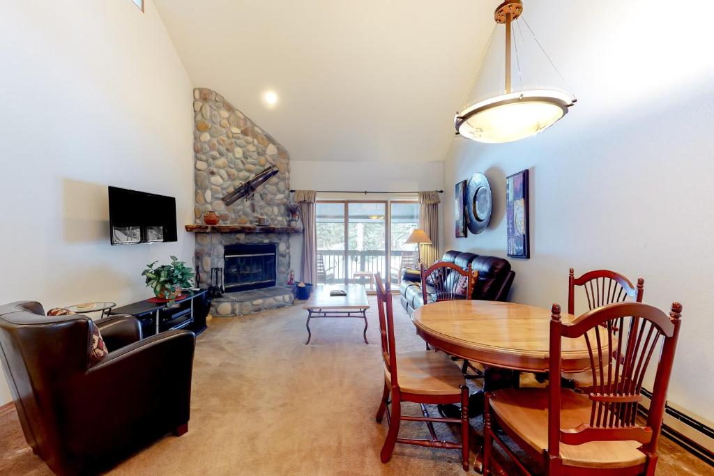 a living room with a table and a fireplace at Silverpick #303 - River Rock Retreat in Durango