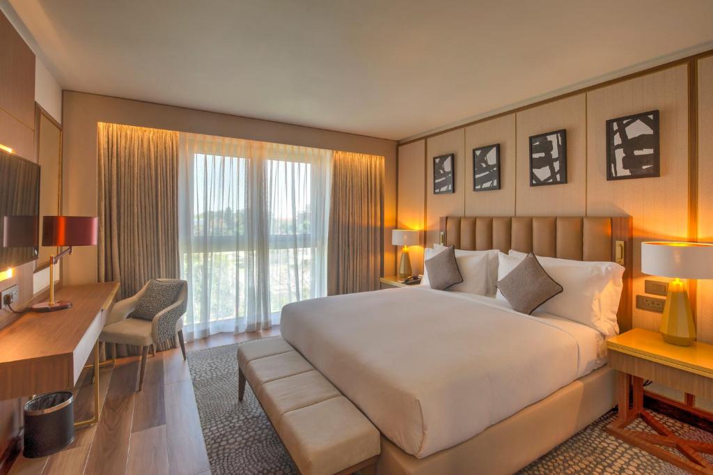 a large bedroom with a large white bed and a desk at InterContinental Lusaka by IHG in Lusaka