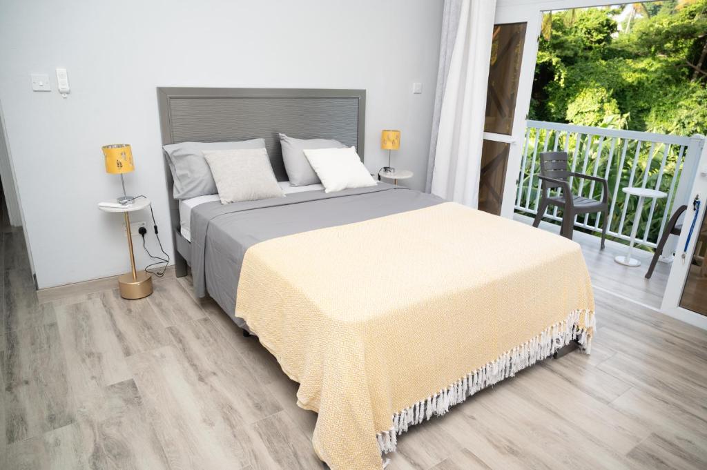 a bedroom with a large bed and a balcony at La Retraite Apt in Rodney Bay Village
