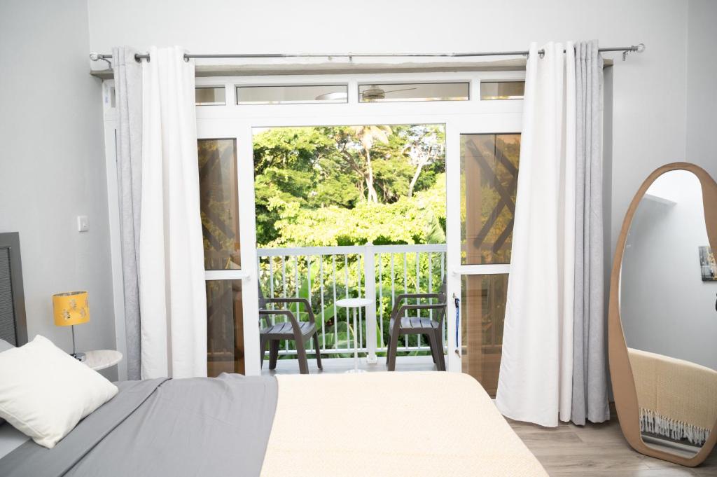a bedroom with a bed and a sliding glass door at La Retraite Apt in Rodney Bay Village