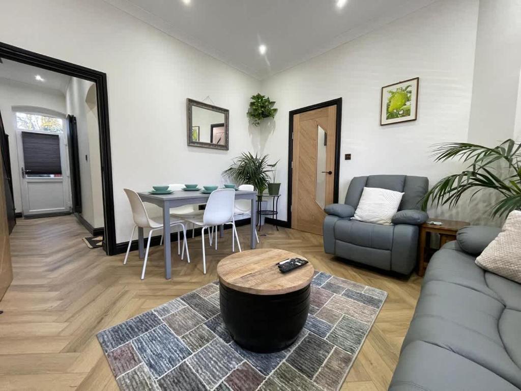 a living room with a couch and a table at Exchange House - FREE Parking - 3 En-Suite Bedrooms - Close to M5-J2 and Train Station - Good connection to city centre - Close to Metro Extension to Briery Hill in Birmingham