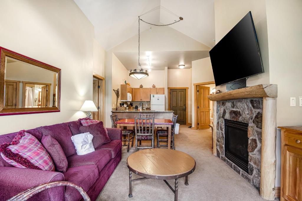a living room with a purple couch and a fireplace at Lofty Quarters #409 in Wheeler Junction