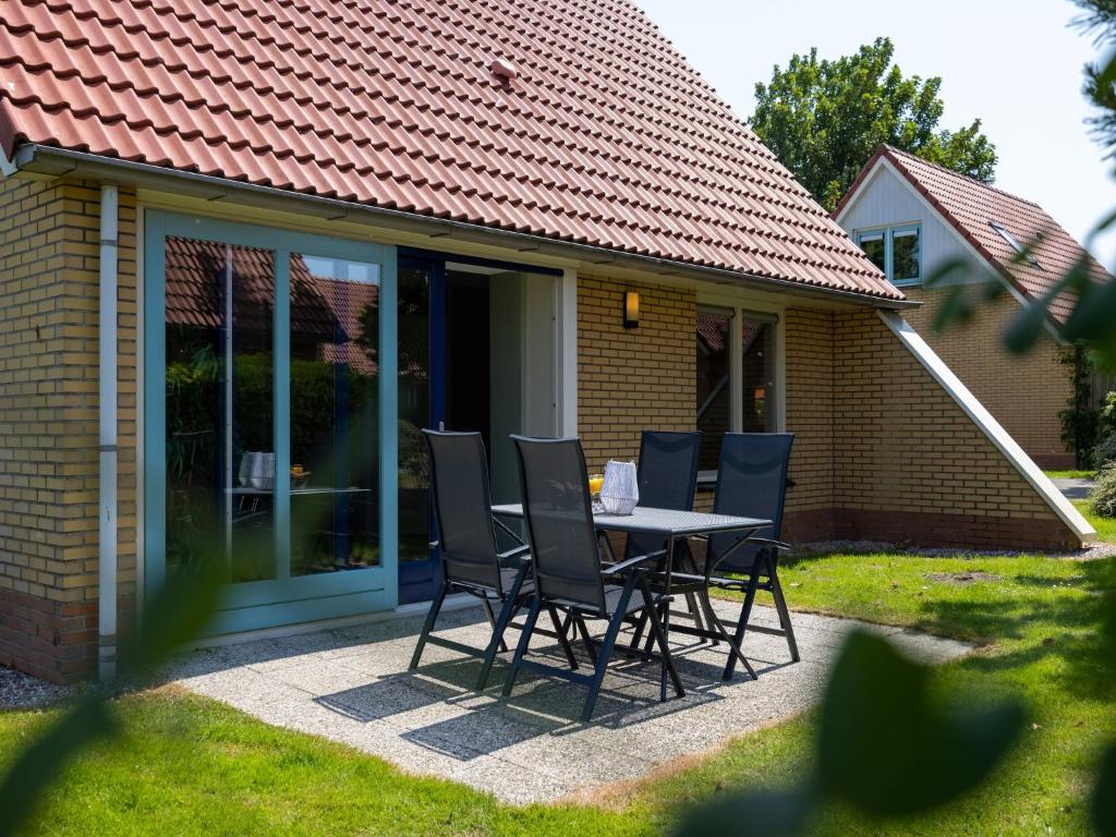 a table and chairs in front of a house at Villa in Netherlands with Spacious Garden in Andijk