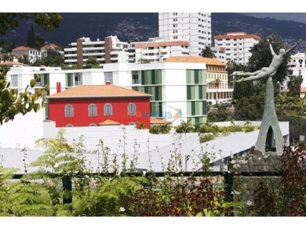 uma vista para uma cidade com um edifício vermelho em Quinta da Nogueira no Funchal