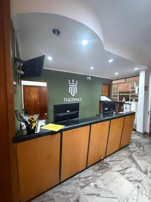 una recepción del hotel con un cartel en la pared en Hotel Thermas da Mantiqueira - Poços de Caldas - De frente para a Praça Central, en Poços de Caldas