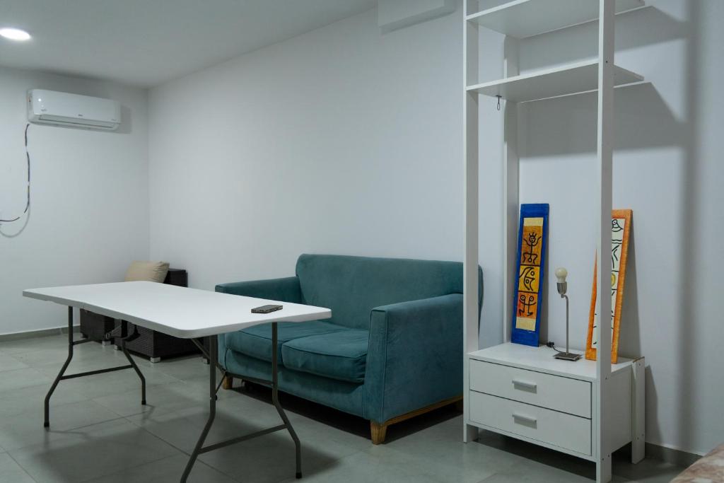 a room with a blue chair and a table and a book at México 1510 - Neuquén Centro in Neuquén
