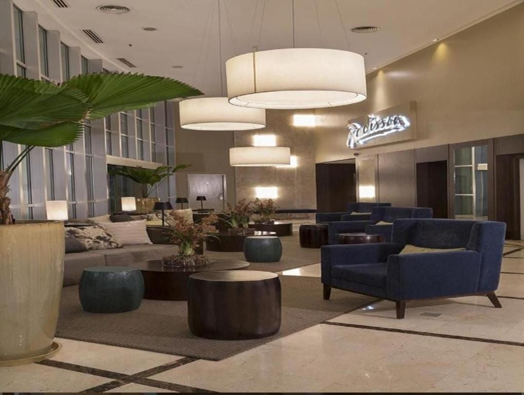 a lobby with couches and tables in a hotel at Flat Conforto Luxo Vila Olimpia in Sao Paulo