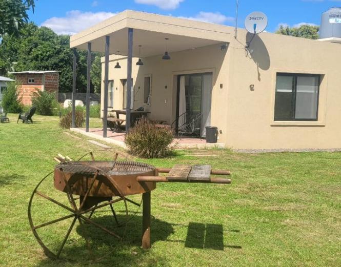 Eine Schubkarre steht im Hof vor einem Haus in der Unterkunft Casa de Campo Vuelta de Obligado in Vuelta de Obligado