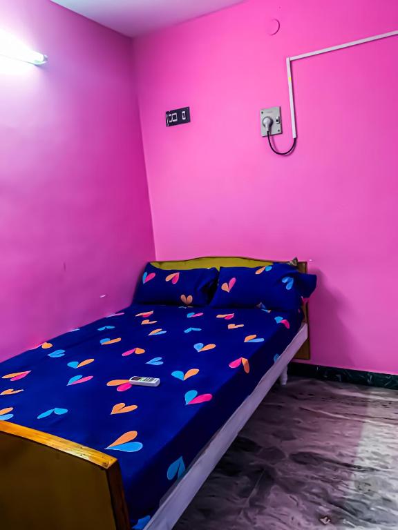 a bedroom with a bed in a pink room at MK Residency Rooms in Tiruvannāmalai