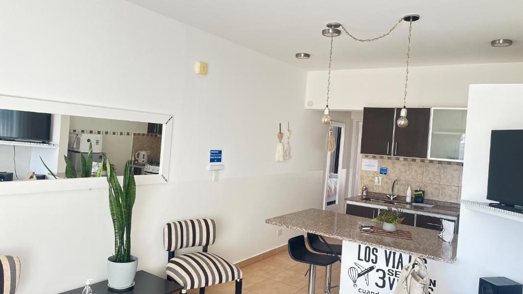 - une cuisine avec un comptoir et des chaises dans la chambre dans l'établissement Los Soles de Madryn, à Puerto Madryn