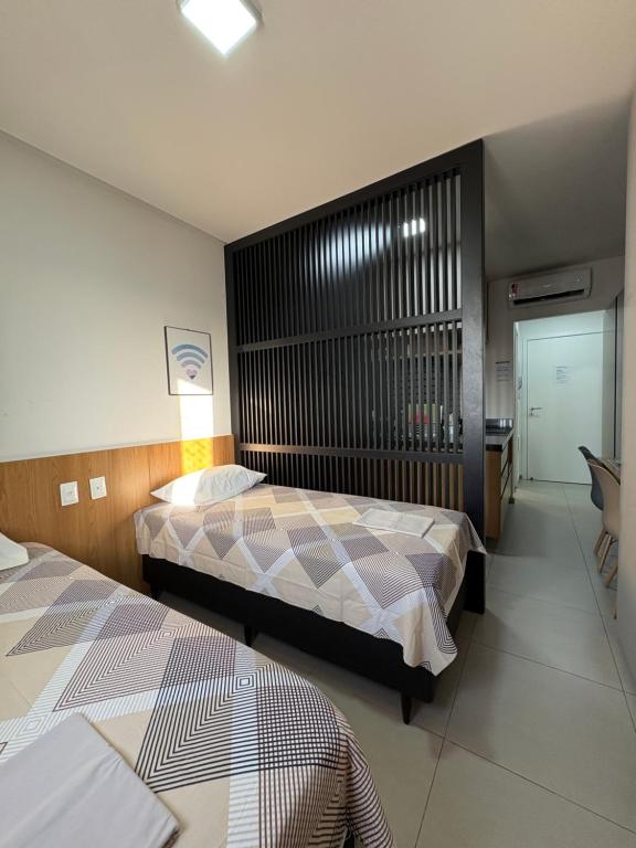 ein Hotelzimmer mit zwei Betten und einem Schreibtisch in der Unterkunft Westfit Barreto 01 in Mossoró