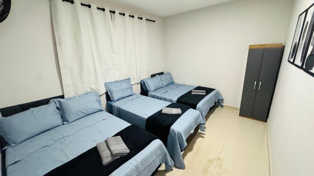 a room with three beds and a couch at Casa Família no Parque Edu Chaves in Sao Paulo