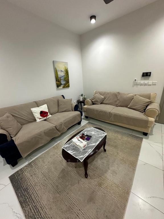 a living room with two couches and a coffee table at Moroj Al Zain - M82 in Salalah