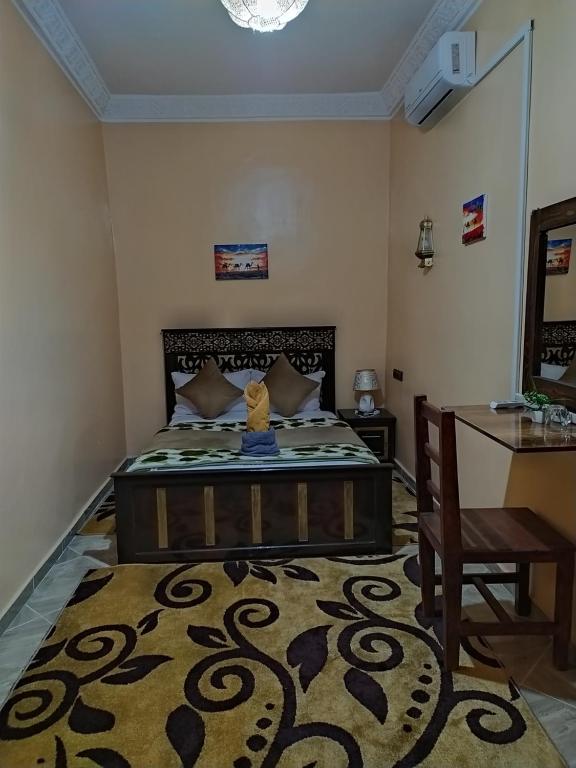 une chambre avec un grand lit et une table dans l'établissement Sahara Dream Apartment, à Merzouga