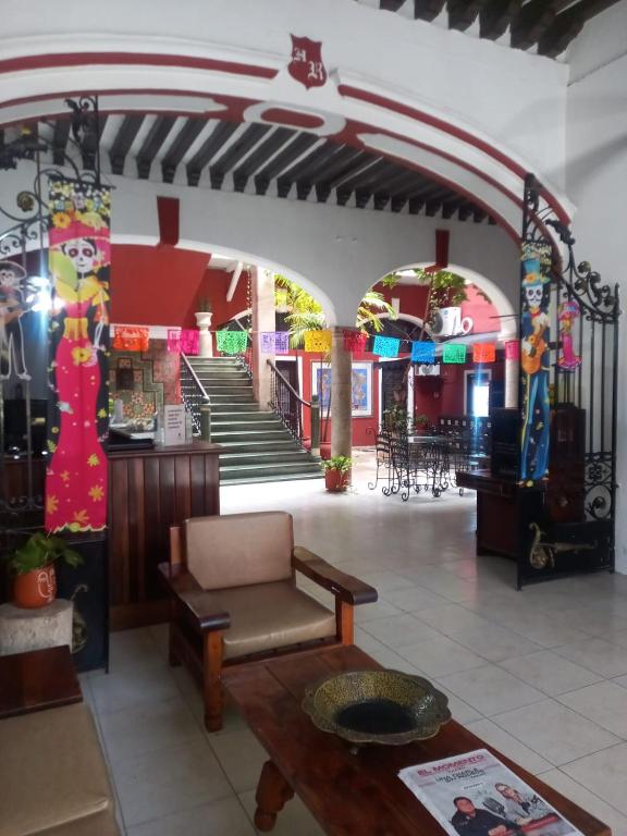 Un vestíbulo de un centro comercial con un sofá y una mesa. en Hotel Reforma, en Mérida