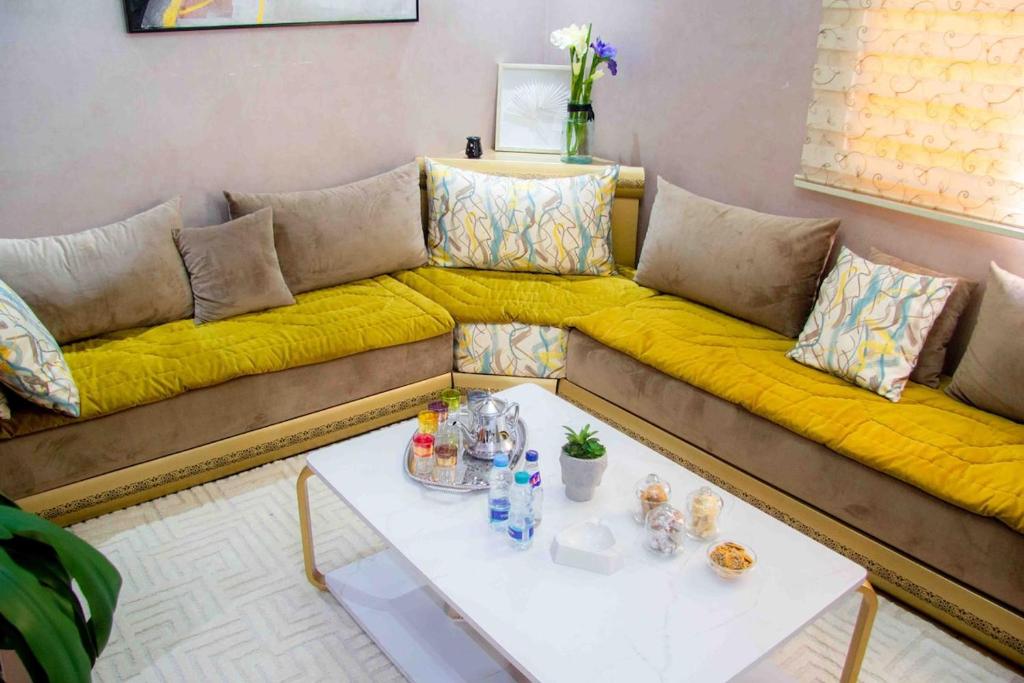 - un salon avec un canapé et une couverture jaune dans l'établissement Cozy apartment in Rabat Agdal, à Rabat