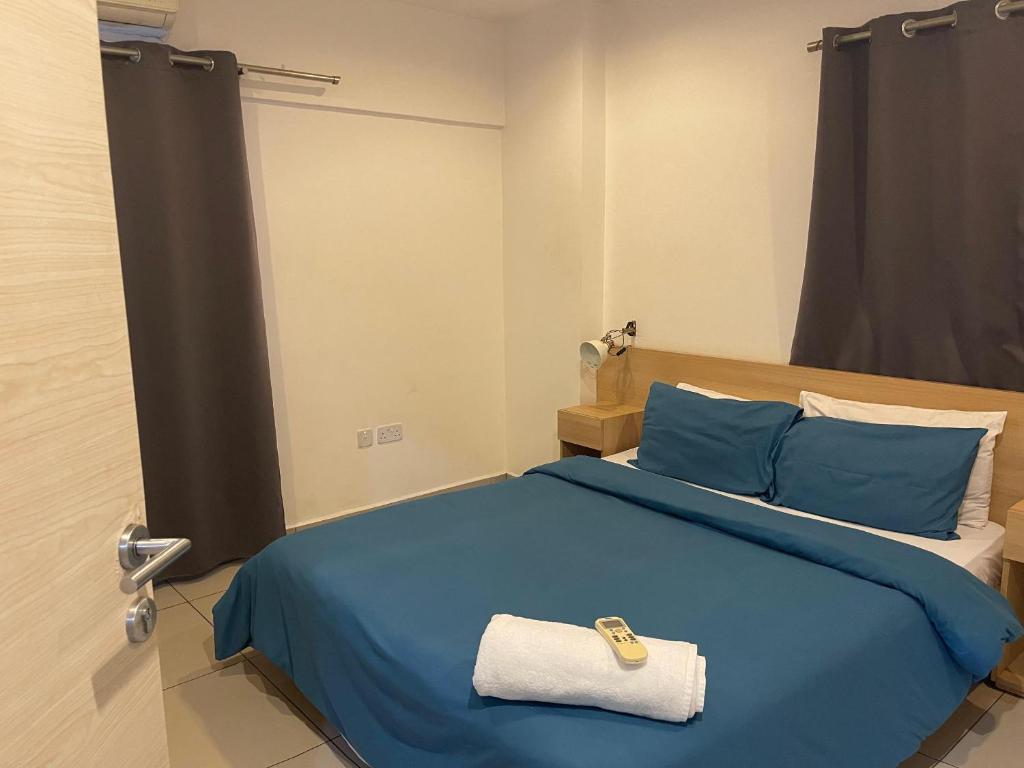 - une chambre avec un lit bleu et une serviette dans l'établissement Kings Luxury 1 bedroom at Gallery, à Accra