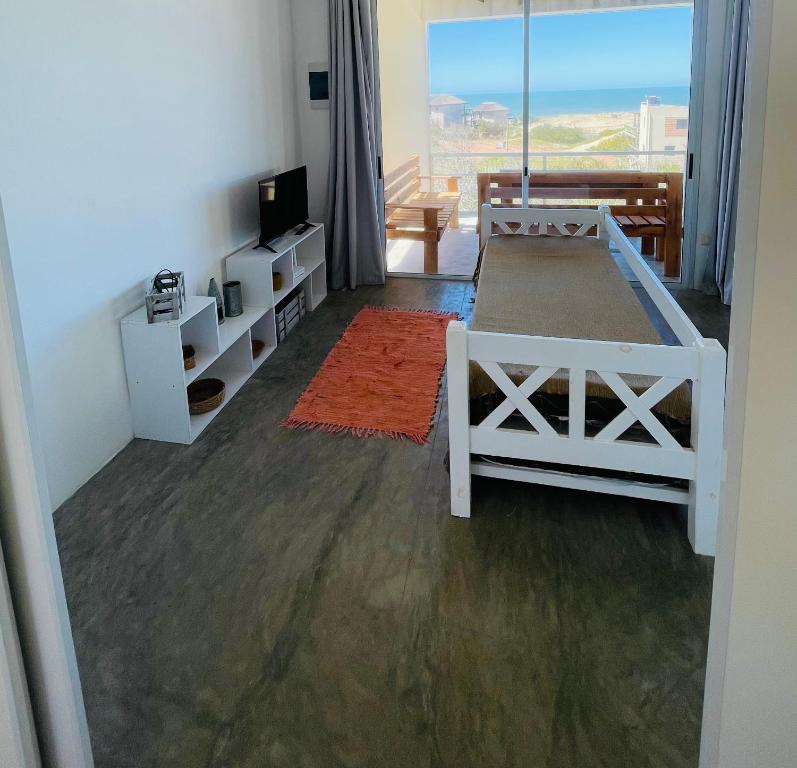 a bedroom with a bed and a room with a window at Acacias PDD in Punta Del Diablo