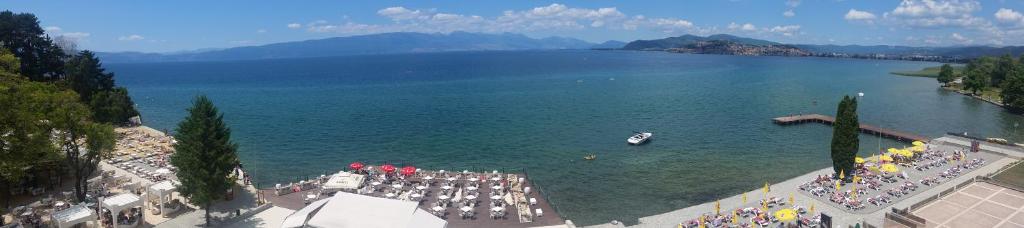 Blick auf einen großen Wasserkörper mit einem Boot in der Unterkunft Sunnyview Park Ohrid apartments in Ohrid