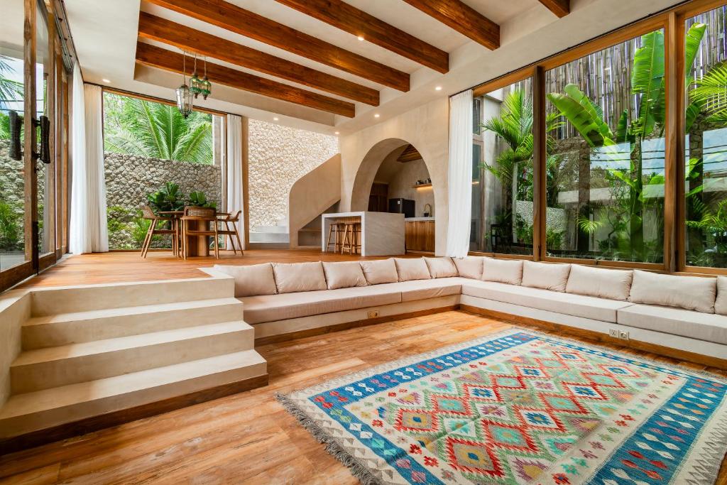 a living room with a couch and large windows at MINTU Villa Uluwatu - BBQ, Private Pool & Concierge Service in Bingin Beach