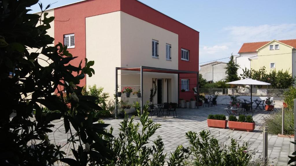 - un bâtiment rouge et blanc avec une terrasse dans l'établissement Apartments A-Mol, à Zadar