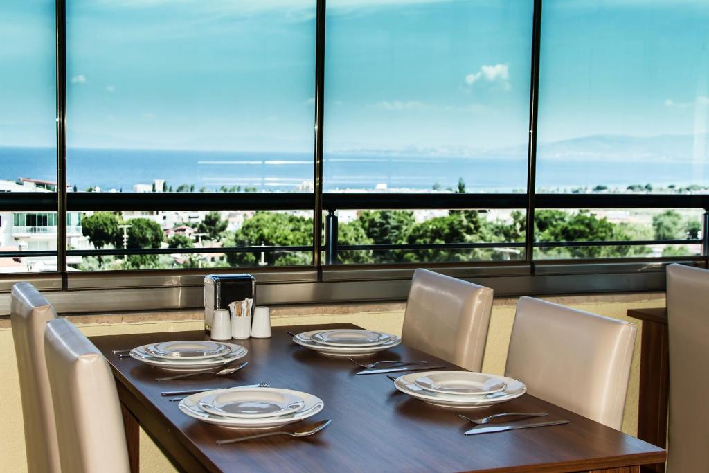 a dining room table with chairs and a view of the ocean at Misa Pension Apart in Guzelcamlı