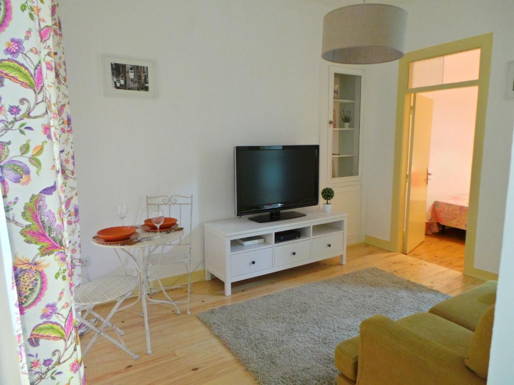 una sala de estar con TV en un armario blanco en Barracão de Alfama Apartments, en Lisboa