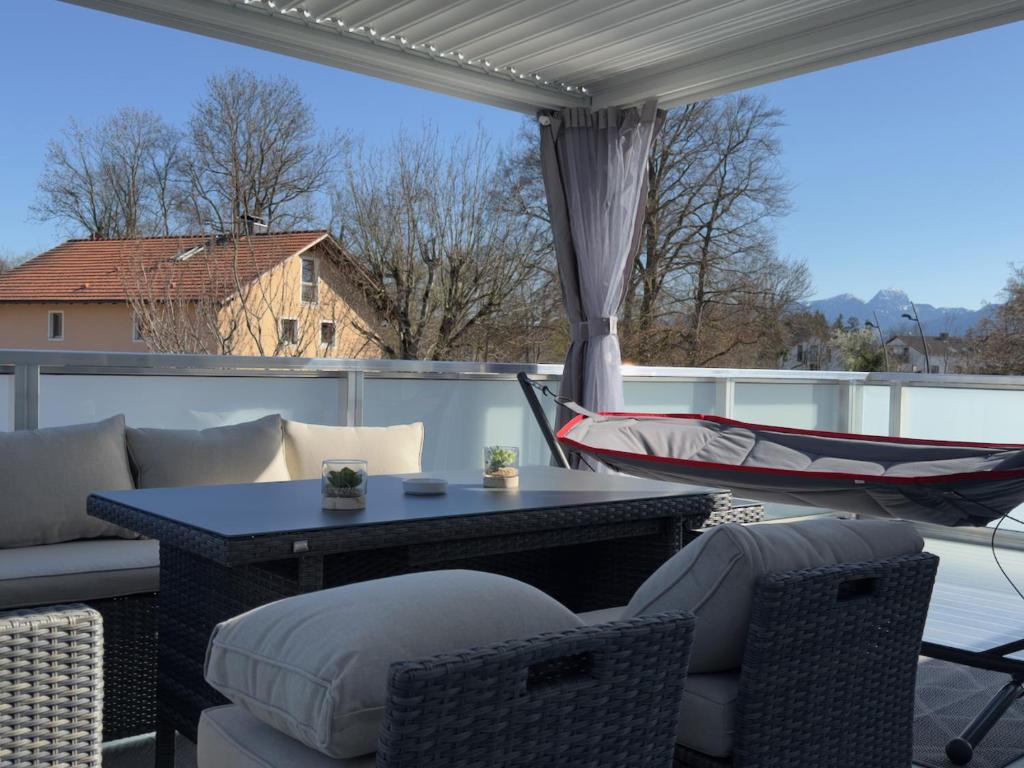 a patio with a hammock and a table and chairs at Thermenblick in Bad Aibling