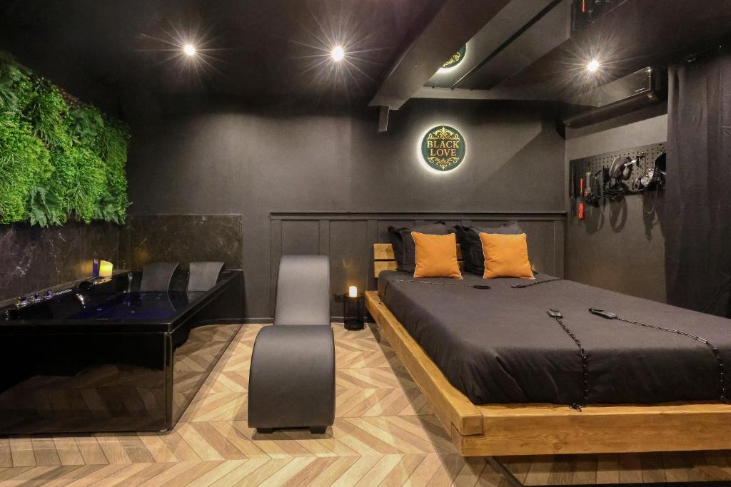 Un dormitorio con una cama, una bañera y un lavabo. en BlackLove room, en La Ciotat
