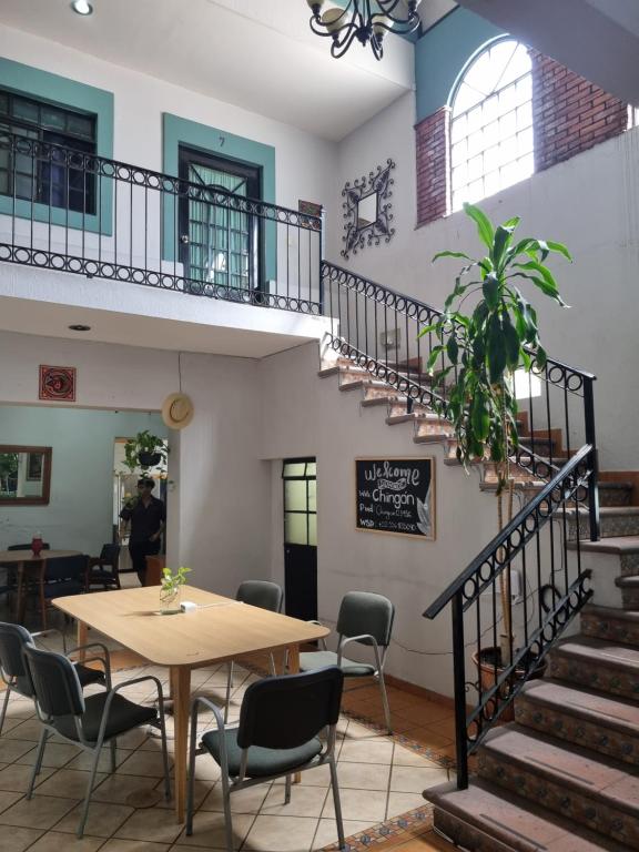 a table and chairs in a room with a staircase at Suites Chingón in Guadalajara