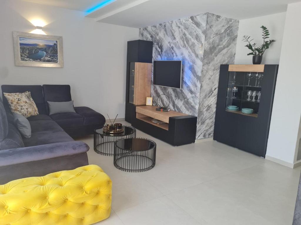a living room with a couch and a tv at Villa I&N - Four Bedroom Villa in Imotski