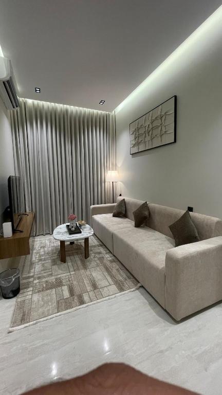 a living room with a couch and a table at غرفة وصالة فندقية في حي الورود in Al Kharj