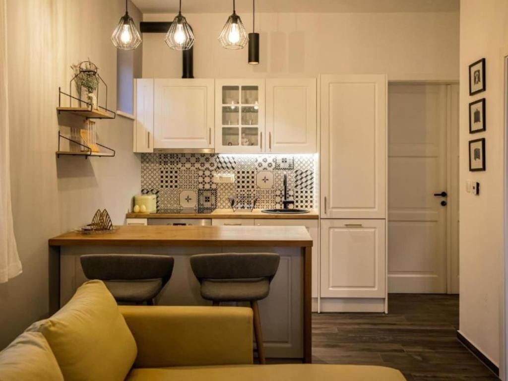 a kitchen with white cabinets and a counter with stools at Luxury Villa Lara with Heated Pool, Hot-Tub and Sauna - Six Bedroom Villa with Pool in Zmijavci