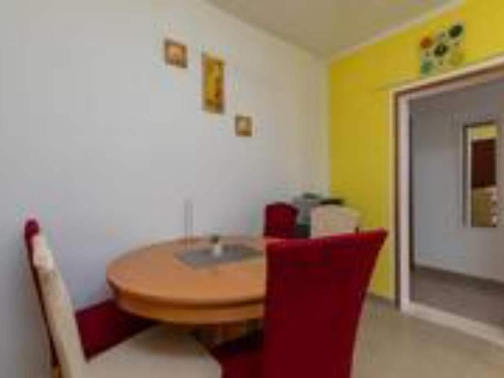 comedor con mesa de madera y sillas rojas en Apartments Roma - Two Bedroom Apartment, en Celina