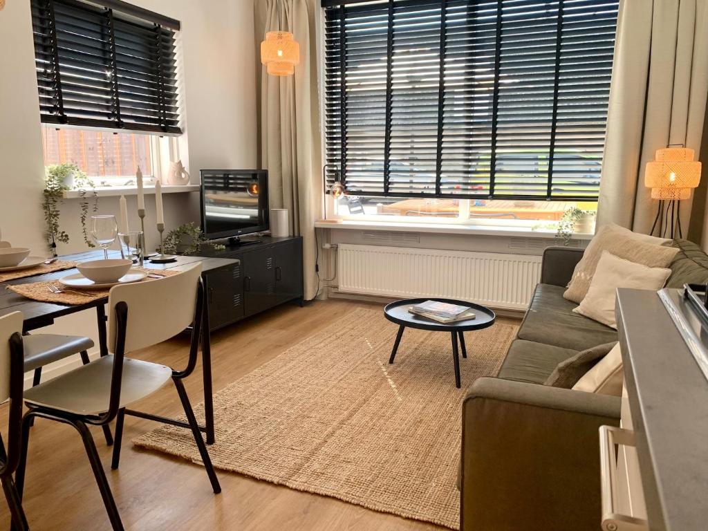 a living room with a couch and a table at Holiday Home in Petten near the Beach in Sint Maartensvlotbrug