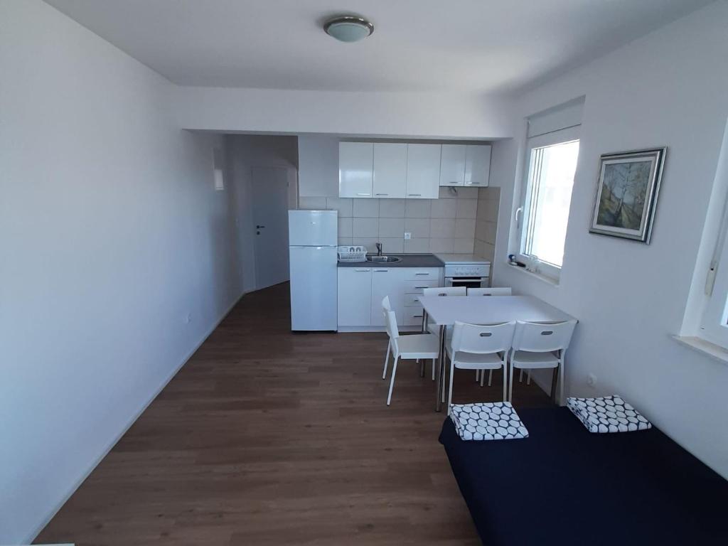 a kitchen with a table and chairs in a room at One-Bedroom Apartment A1 in Stošići