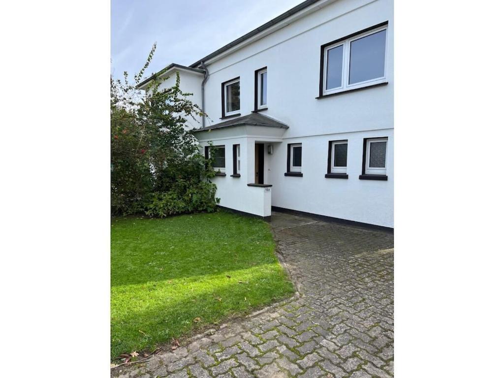 a white house with a green lawn in front of it at Holiday apartment in Hanover with barbecue in Hannover