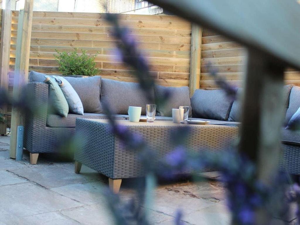 a couch on a patio with two cups on a table at One-bedroom apartment in Waterakkers