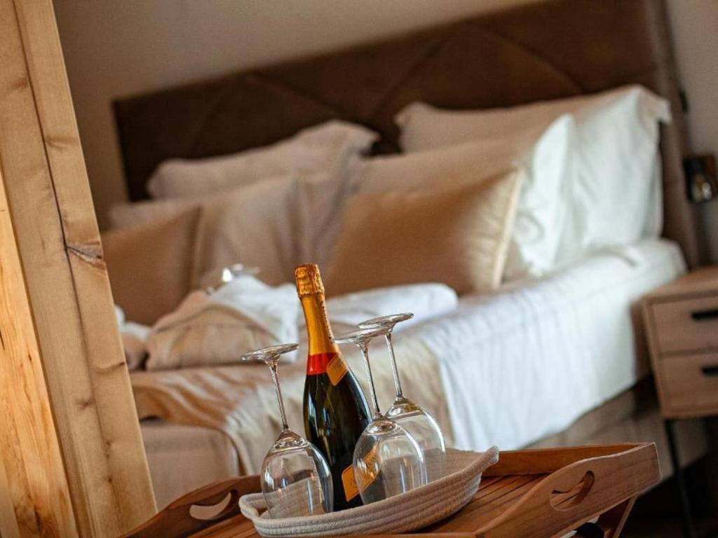 two bottles of wine on a table in front of a bed at Family Resort Plitvice Lakes- Mountain view Tina in Rastovača