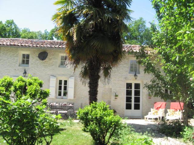 dom z palmą przed nim w obiekcie Gite du Calme 3 Star Bed & Breakfast Cognac w mieście Chérac