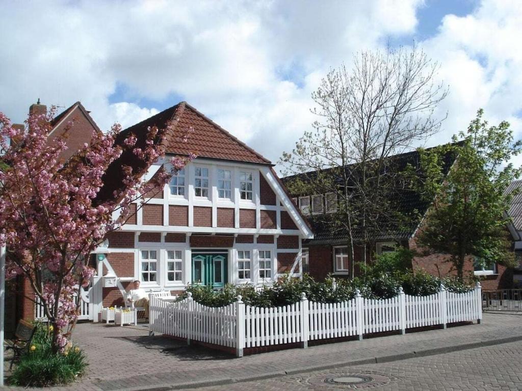 a house with a white fence in front of it at Holiday apartment 2 people in Borkum