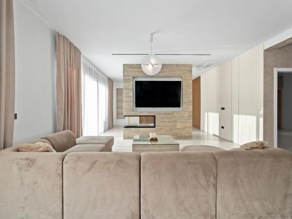 un soggiorno con divano e TV a schermo piatto di Villa Freedom - Five Bedroom House with Balcony a Mala Čista