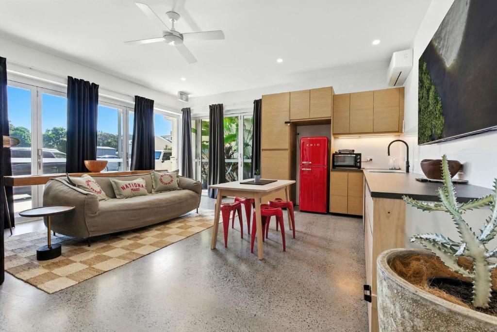 Una cocina y una sala de estar con un sofá y un refrigerador rojo. en C & C by the Sea Studio, en Coolum Beach