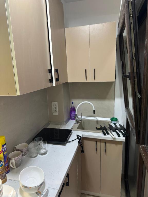 Una pequeña cocina con gabinetes blancos y un fregadero. en Apartament Saturn Beta, en Mangalia