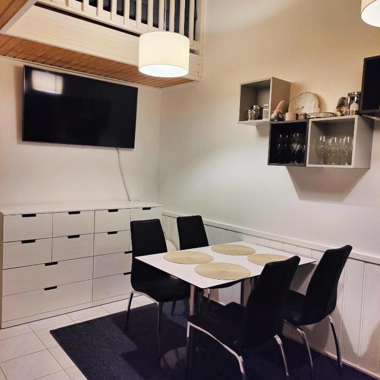 a dining room with a table and chairs and a tv at Levin KUURA in Kittilä
