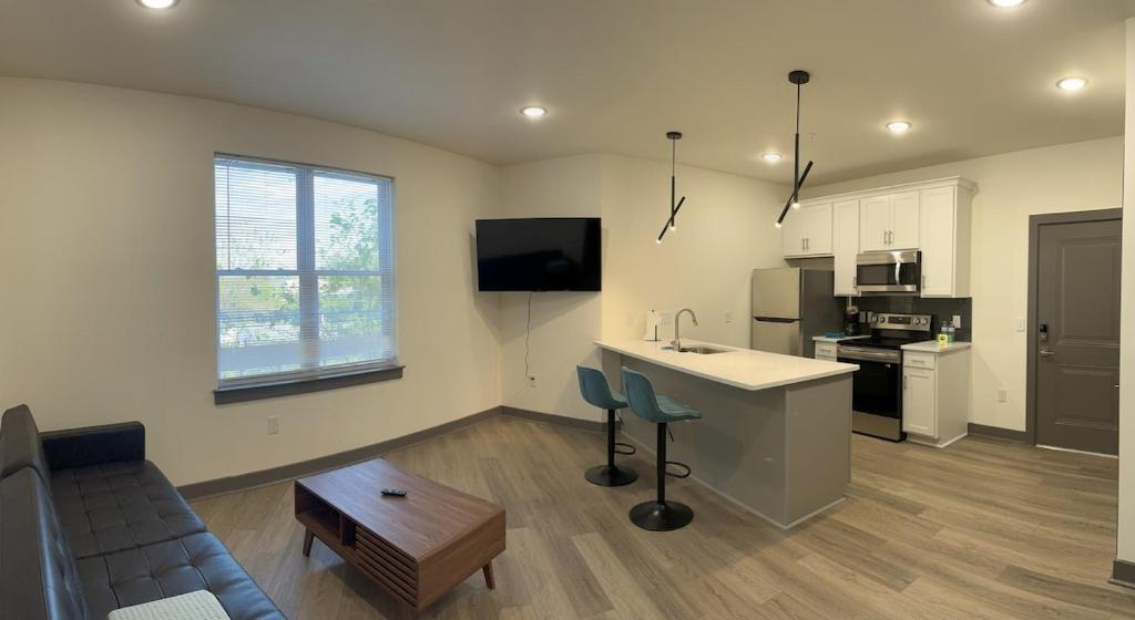 a kitchen and living room with a couch and a table at Richmond Church Hill North Deluxe Apt 208 in Richmond