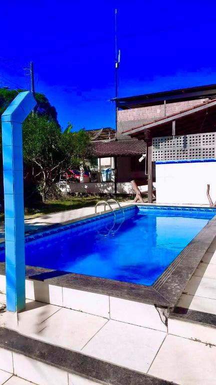 a large blue swimming pool in front of a building at Casa de tartaruga em Guarapari in Guarapari