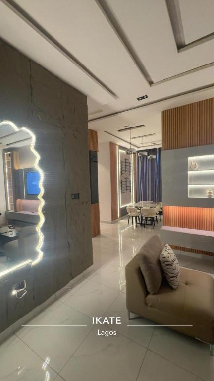 una sala de estar con un sofá y una mesa en Ikate serenity suites 2BR with Pool, Ps5 & wifi, en Moba