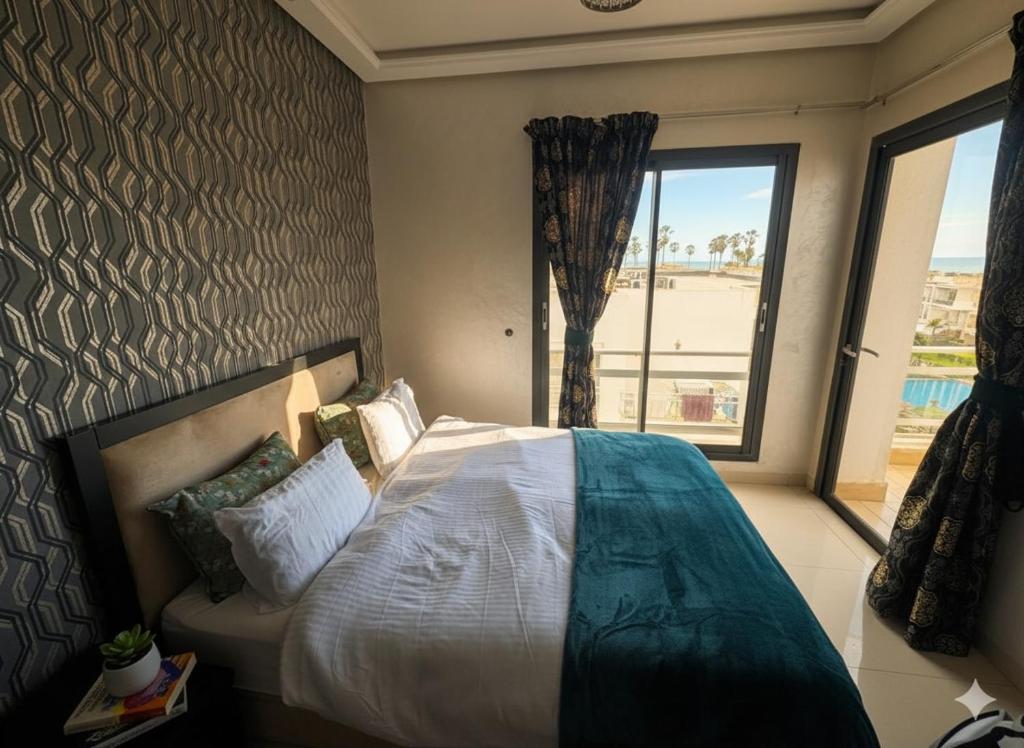 TamarisにあるBeachside Charming Apartmentのベッドと大きな窓のある寝室