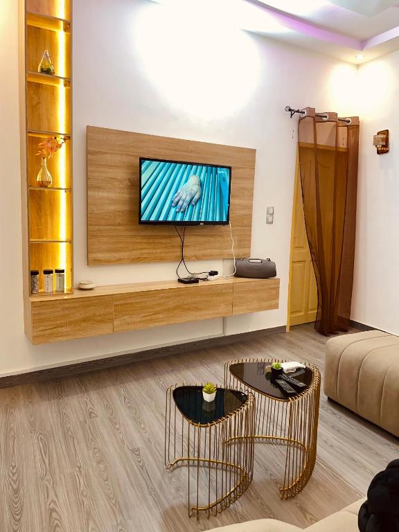 a living room with a television and two chairs at Sucram Appartement in Abomey-Calavi